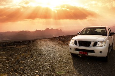 Off-road aracı Jebel Shams dağlar ve şaşırtıcı yapraklara ile bulutlu gökyüzü