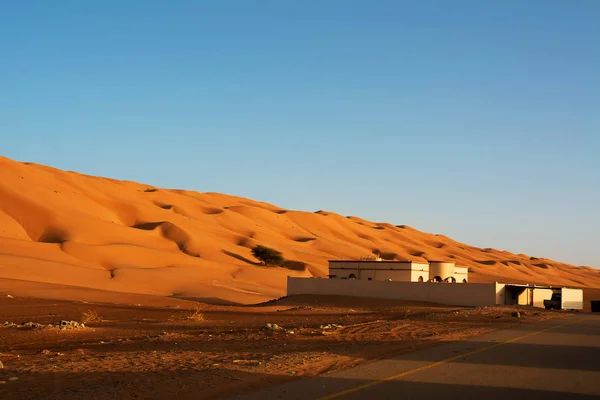 Residential building under the desert dunes wahiba sands at sunset (Oman)