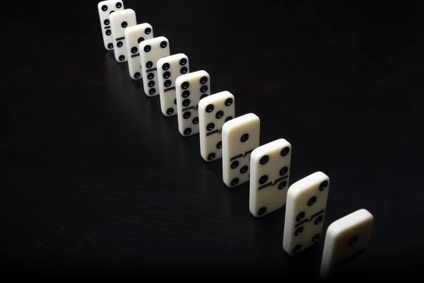 Fichas de dominó en una fila sobre un fondo negro — Foto de Stock