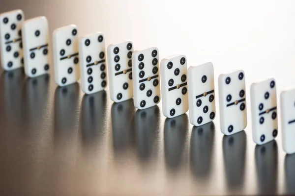 Fichas de dominó en una fila sobre un fondo negro — Foto de Stock