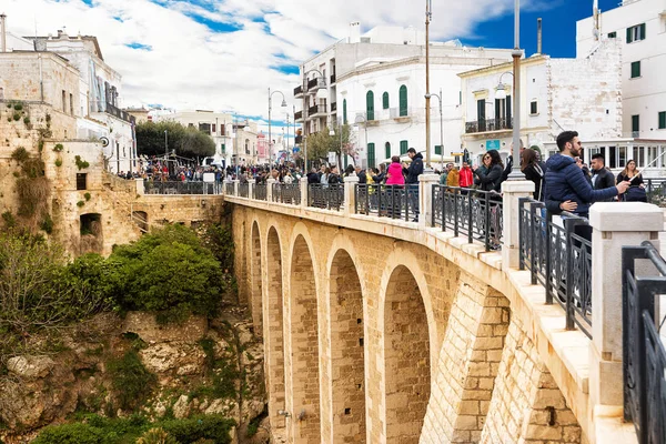 Turyści na mostku Lama Monachile w Polignano a Mare (Włochy — Zdjęcie stockowe