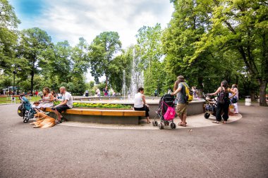 İnsanlar p bir çeşme ile büyük bir çeşme etrafında rahatlatıcı