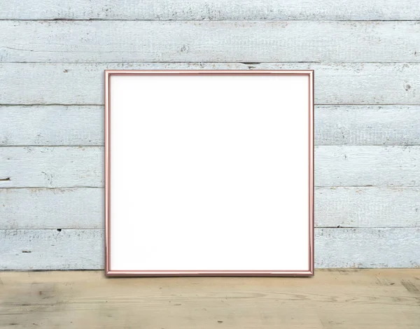 Rose Gold square Frame mockup stands on a wooden table on a pain