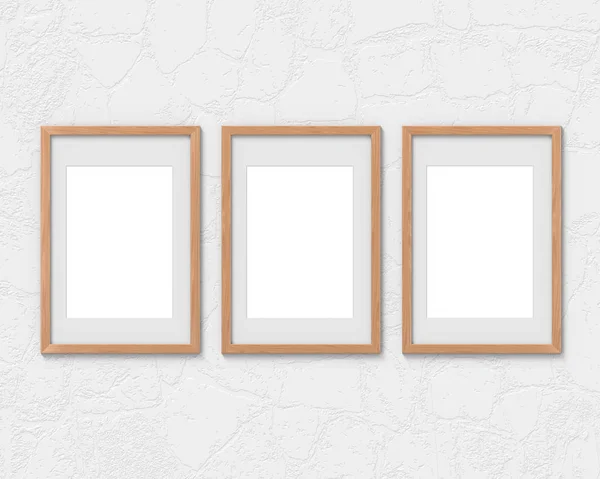 Set of 3 vertical wooden frames mockup with a border hanging on the wall. Empty base for picture or text. 3D rendering. — Stock Photo, Image