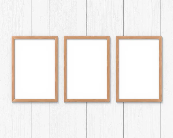 Set of 3 vertical wooden frames mockup with a border hanging on the wall. Empty base for picture or text. 3D rendering. — Stock Photo, Image