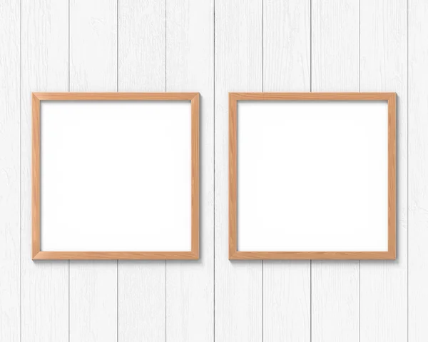 壁に掛かっている2つの正方形の木製フレームのモックアップのセット。画像またはテキストの空のベース。3D レンダリング. — ストック写真