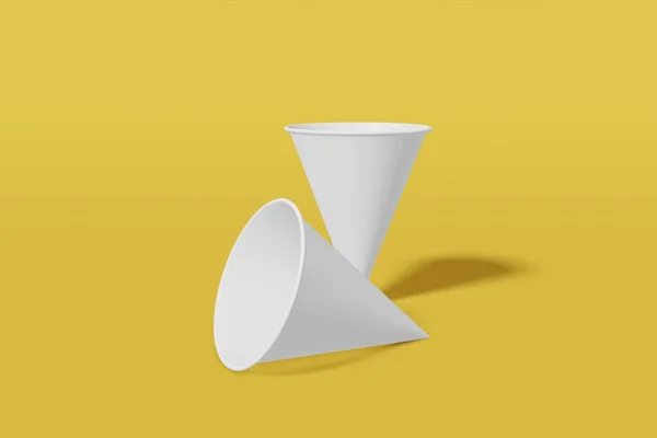 Набір з двох білих паперових макетів чашок конуса, що утворюються на жовтому тлі. 3D візуалізація — стокове фото