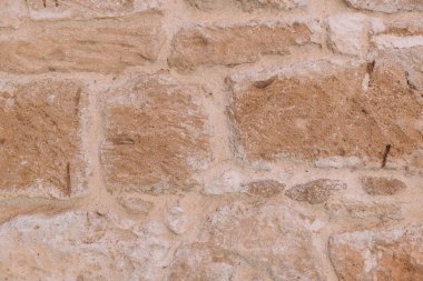 Düzensiz şekilli bloklardan yapılmış kumtaşı duvar. Yatay görüş. Yakın plan..