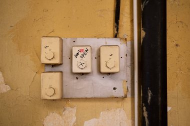 Eski kontrol paneli grunge duvarında. Vintage ışık yuvarlak anahtar konsolu. Siyah kalemli el yazısı. Açma.