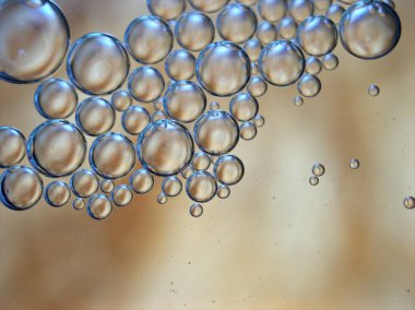 Güzel soyut baloncuklar suda yağlı bembeyaz arka plan, makro görüntü, sarı damlacıklar.