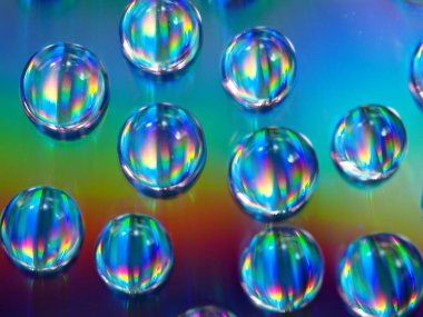 Renkli ve parlak mavi arkaplanda su damlacıkları, makro görüntü, kristal damlalar soyut, gökkuşağı rengi