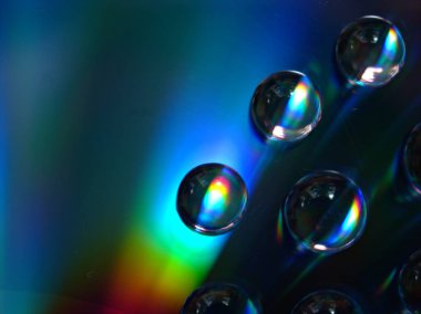 Renkli ve parlak mavi arkaplanda su damlacıkları, makro görüntü, kristal damlalar soyut, gökkuşağı rengi