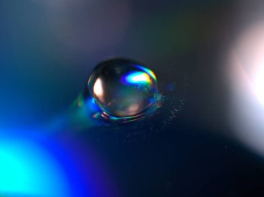 Yakın plan su ikizleri koyu mavi arkaplanda, damlalar mavi parlak ve bulanık, makro görüntü, soyut arkaplan