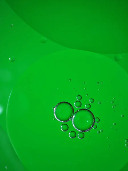 Closeup macro drops of oil in water with colorful background ,beautiful green abstract bubbles oil ,droplets on pastel background