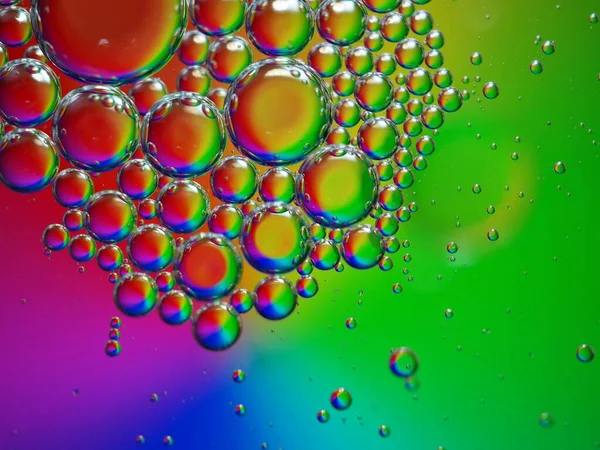 Closeup macro drops of oil in water with colorful background ,beautiful green abstract bubbles oil ,droplets on pastel background