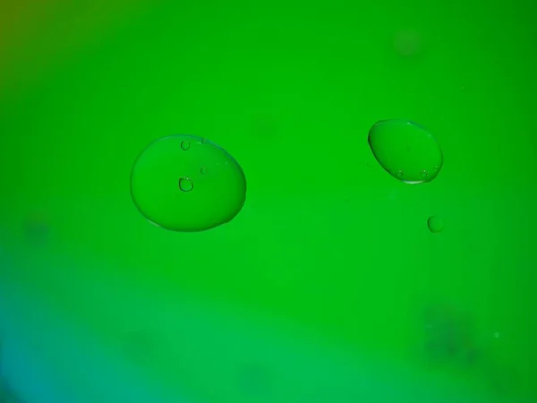 Closeup macro drops of oil in water with colorful background ,beautiful green abstract bubbles oil ,droplets on pastel background