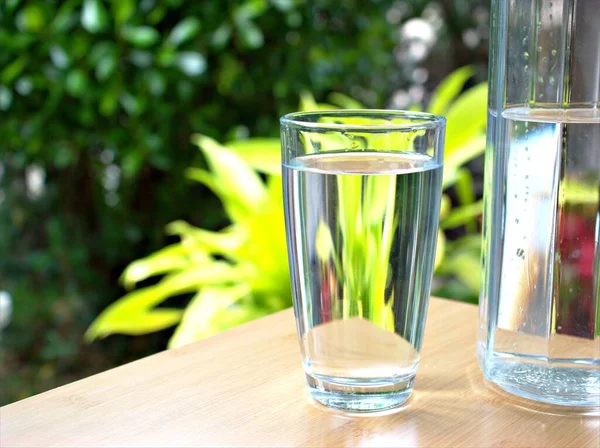 Acqua Potabile Viene Versata Una Brocca Vetro Giardino Verde Sfondo — Foto Stock