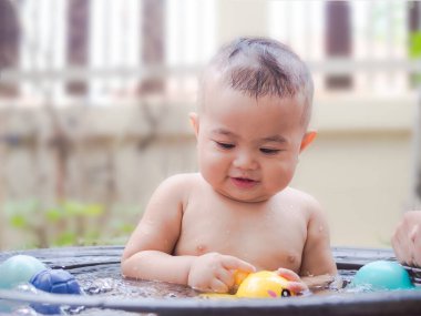 Portre çocuğu. 9 aylık. Arka planda duş alıyor. Mutlu aile kavramı.