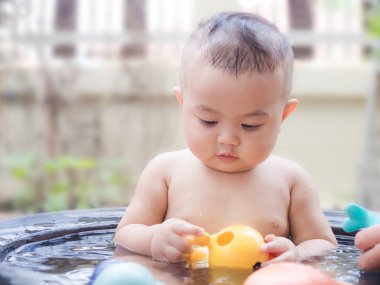 Portre çocuğu. 9 aylık. Arka planda duş alıyor. Mutlu aile kavramı.