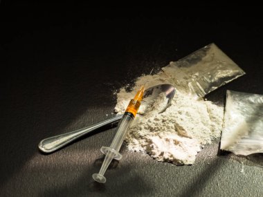 Eroin, iğne, eski kaşık, siyah arka planda iğne. Eroin ağır uyuşturucudur. Uyuşturucu Eğlence Konsepti.