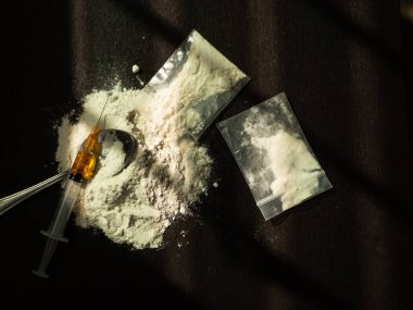 Eroin, iğne, eski kaşık, siyah arka planda iğne. Eroin ağır uyuşturucudur. Uyuşturucu Eğlence Konsepti.