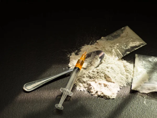 Eroin, iğne, eski kaşık, siyah arka planda iğne. Eroin ağır uyuşturucudur. Uyuşturucu Eğlence Konsepti.