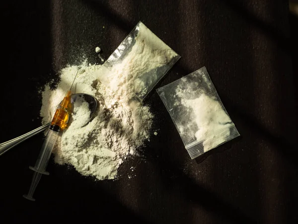 Eroin, iğne, eski kaşık, siyah arka planda iğne. Eroin ağır uyuşturucudur. Uyuşturucu Eğlence Konsepti.