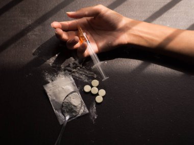 Eroin, enjeksiyon, eski kaşık, elinde siyah ahşap arka planda Asyalı kadınlar olan iğne. Eroin ağır uyuşturucudur. Uyuşturucu Eğlence Konsepti.