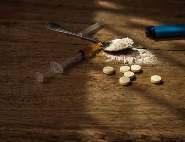 Heroin, injection, old spoon,injection needle,lighter on dark wooden black background. heroin is hard drugs. Narcotic Recreational drugs concept.