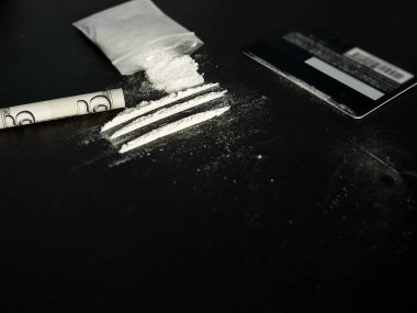 Kokainin bulanık görüntüsüyle bölünmüş yuvarlak banknot, kredi kartı, plastik pakette kokain. madde bağımlılığı veya uyuşturucu kavramı.