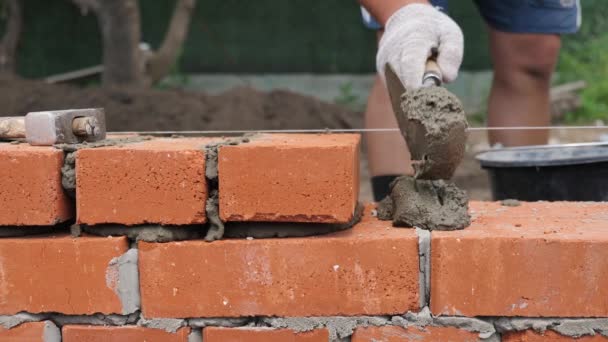 Trabalhador da construção civil ou pedreiro industrial deitado tijolo vermelho — Vídeo de Stock