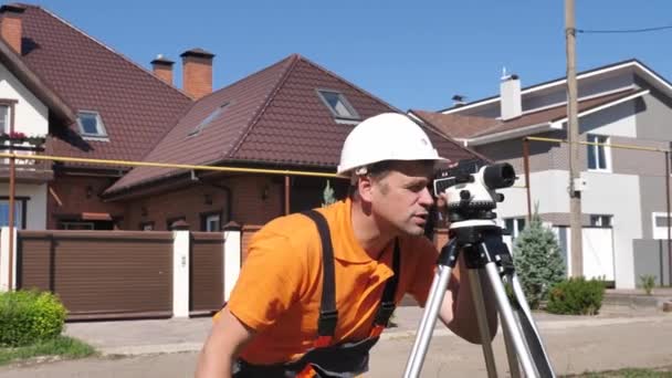 Engenheiro profissional Surveyor toma medidas com instrumento de nivelamento no canteiro de obras — Vídeo de Stock