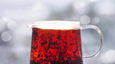 Çay Yaprakları Kaynar suda yüzer Işığın Parıltısında bir çay demliğinde