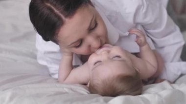 Mutlu Anne Öpücüğü ve Gülüşü. Yatakta birlikte dinlenirken Mutlu Aile Doğumu 