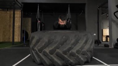Güçlü Adam Egzersiz yaparken Büyük Tekerleği Kaldırıyor Spor ve Crossfit 