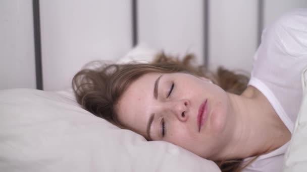 Insonnia, donna irritata che cerca di dormire infastidita dai cattivi vicini rumorosi e copre le orecchie con cuscino — Video Stock