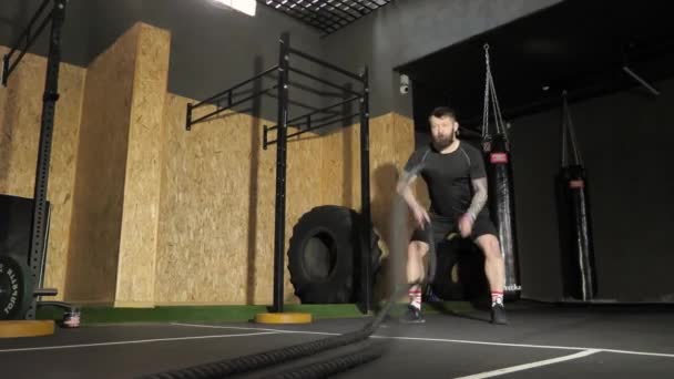 Trening mężczyzn przy użyciu lin bojowych. Intensywny trening w siłowni — Wideo stockowe