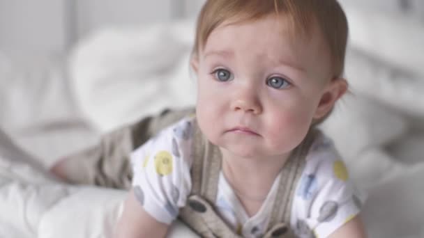 Bebê bonito menino da criança rastejando Explorando com curiosidade se divertindo na cama branca em casa — Vídeo de Stock