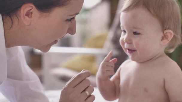 Amare la madre baciare toccando carino giocoso bambino ridendo godendo, nutrendo il bambino a casa — Video Stock