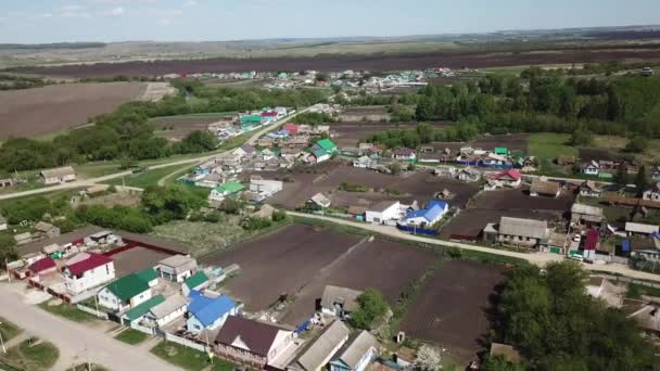 Вид с воздуха на русскую деревню и окружающие сельские луга и поля — стоковое видео