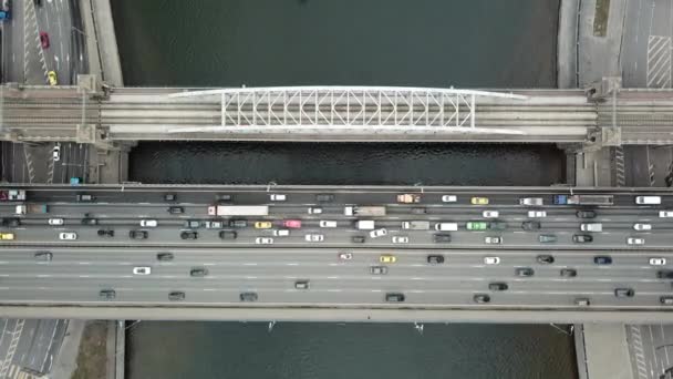 Luchtfoto van de snelweg en brug met auto 's verkeer en bewegende trein. Vervoer over de weg, per spoor en over de rivier in Moskou — Stockvideo