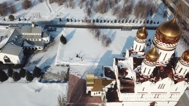 Inspección aérea, volando sobre la catedral cerca de una iglesia con cúpula de oro en invierno. — Vídeos de Stock