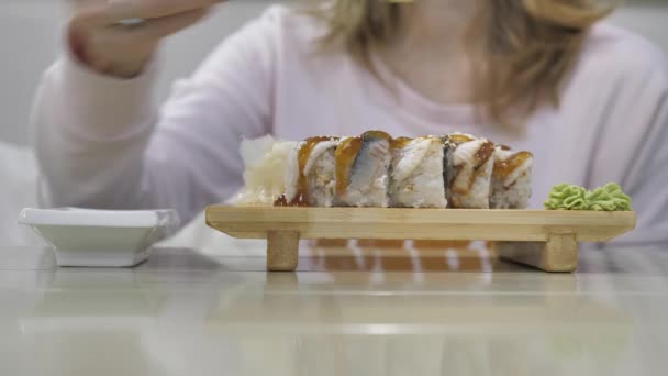 Mladá nepoznatelná žena jíst sushi rolky — Stock video