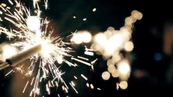 Сверкающий фейерверк с огнями на заднем плане — стоковое видео