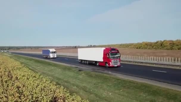 Kilka ciężarówek jadących autostradą, tropiących samoloty. Usługi logistyczne dostaw — Wideo stockowe