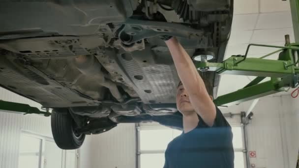 Auto Mechanic Checking Suspension of Lifted Car and Writing on Clipboard — Stock Video