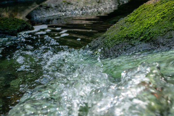 Nehir taşları arasındaki su akışına yakından bak