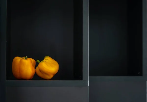 Küçük sarı biber, açık kutunun içindeki büyük olanın üzerinde. 