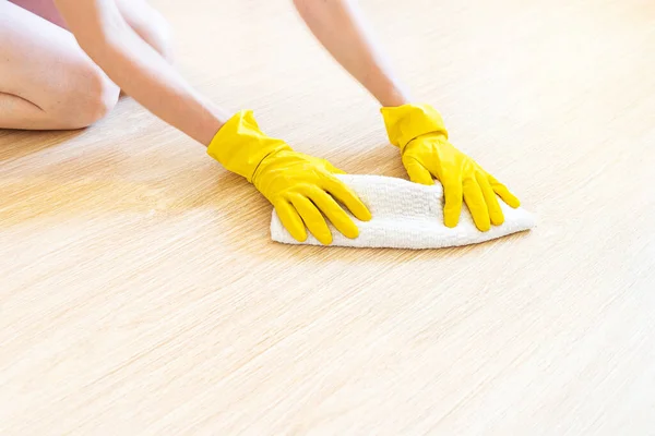 One girl washes the floor in a bright room in yellow household gloves. Clean and fresh.