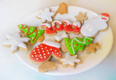 Beyaz tabakta Noel kurabiyeleri yeni yılın başlangıcını ve neşesini temsil eder..